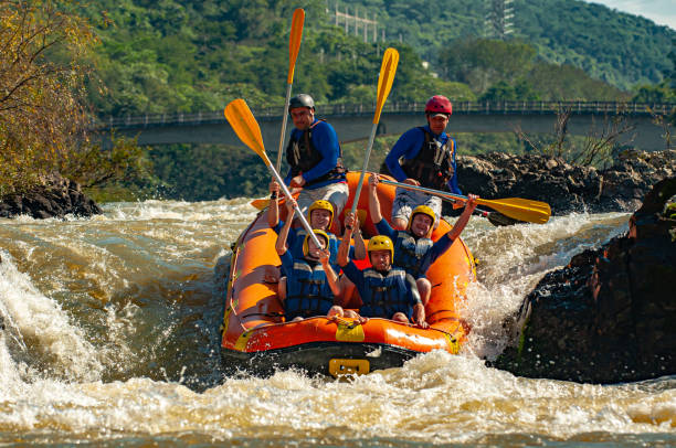 gruppo di amici che fa rafting su un gommone nelle rapide del fiume itajaí-açu, nella città di apiúna a santa catarina. uno dei migliori fiumi del brasile per praticare questo sport - teamwork oar achievement sports team foto e immagini stock