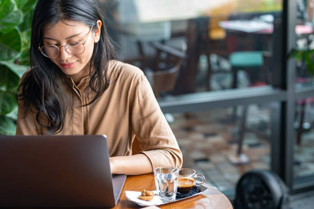 istock Online Learning: Asian College Student Studying on Her Laptop Computer in a Coffee Shop (Copy Space) 1218822030