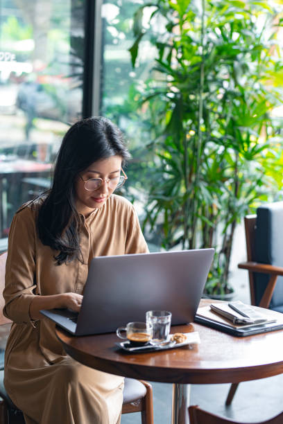 istock Freelancing at a Cafe: Young Asian Entrepreneur Working on Her Laptop Computer 1218822031