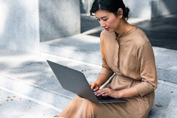 istock Business on the Go: Asian Freelancer Working Online on her Laptop Outdoors 1218822048