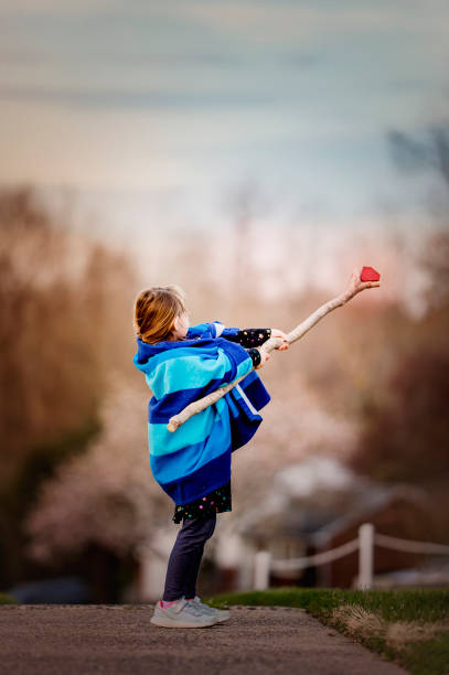 Bambina che gioca finta vestita da mago o mago con Cape e Bacchetta Magica - foto stock