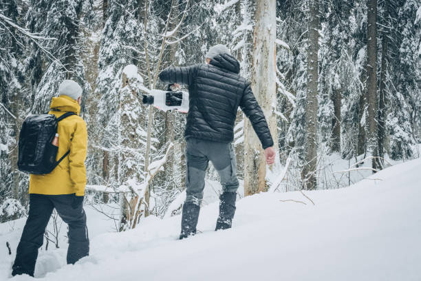 istock Friends hike through snow with video camera 1218825842