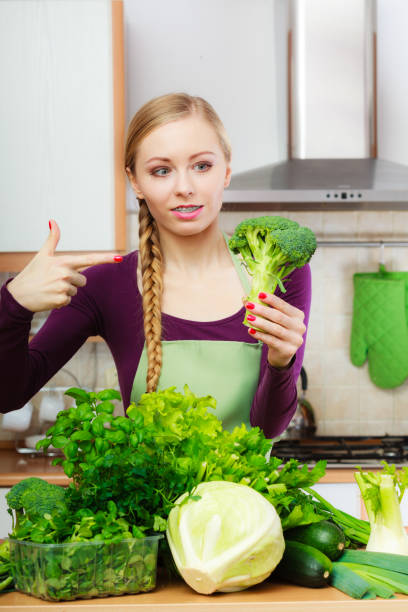 istock Woman in kitchen with green vegetables broccoli in hand 1218825976