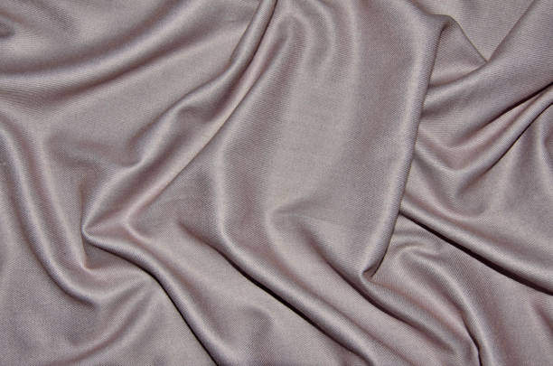 Pale pink woolen with viscose fabric with soft folds - textile background Top view of pale pink woolen with viscose fabric with soft folds - elegant textile background in trendy color. Female accessory - shiny silky scarf texture close up from natural fibers viscose stock pictures, royalty-free photos & images