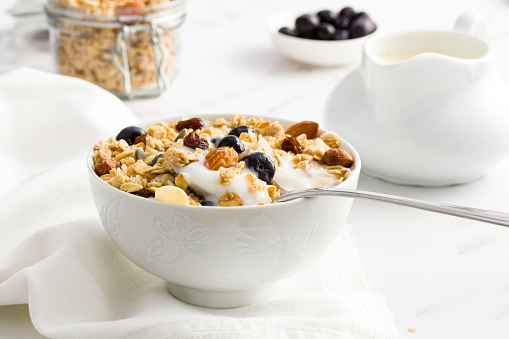 A bowl of breakfast muesli with blueberries and milk