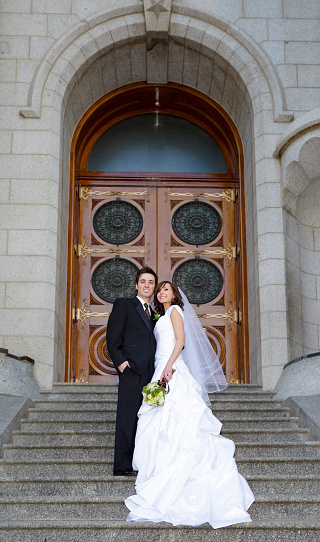 A bride and groom in front of a church.