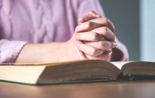 istock prayer woman hand on book 1218828622