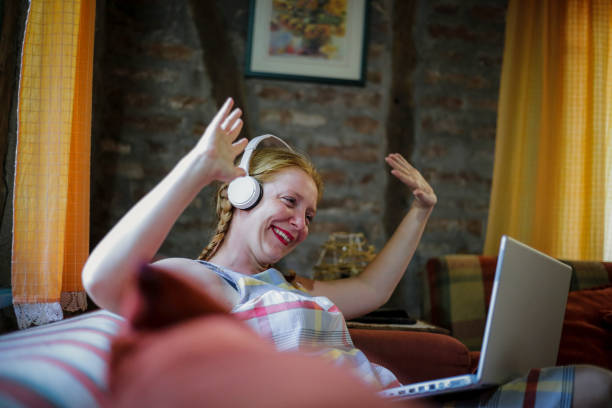 istock Young woman using laptop at home 1218830129