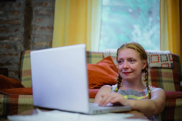 istock Young woman using laptop at home 1218830222