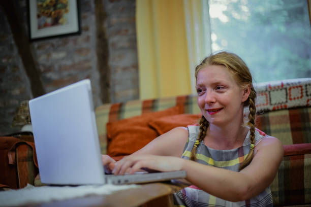 istock Young woman using laptop at home 1218830233