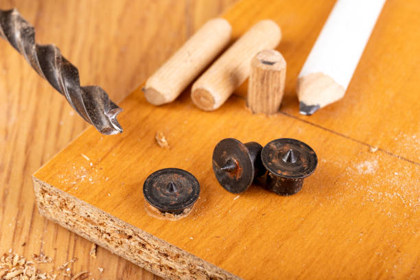 istock Installation of chipboard with carpentry dowels and glue. Small work in a carpentry workshop. Light background. 1218830241