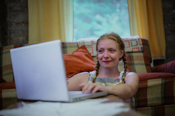 istock Young woman using laptop at home 1218830268