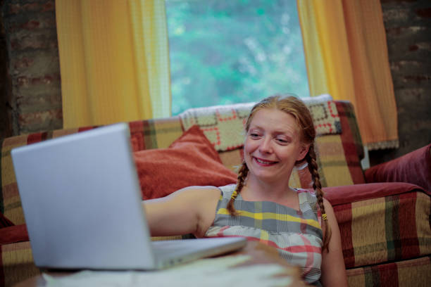 istock Young woman using laptop at home 1218830301