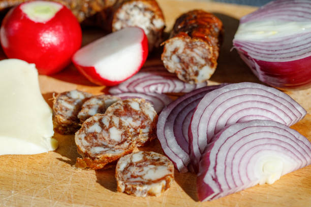 A pile of sausages with rosemary on top. The sausages are cut in half and are arranged in a pyramid shape