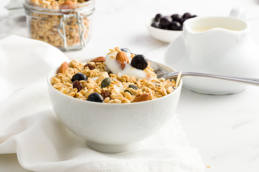 A bowl of breakfast muesli with blueberries and milk