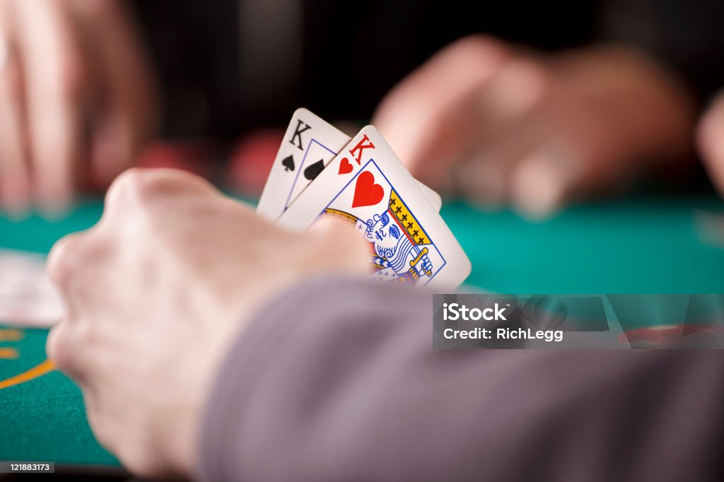 Primo piano delle mani di un giocatore di Poker - Foto stock royalty-free di Re di carte
