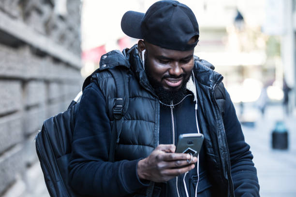 istock Fit young black man walking outdoors with mobile phone 1218831896