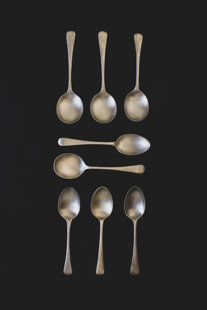 istock Antique silver spoons laid out in patterns on a dark textured background 1218832972