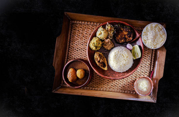 Traditional Bengali food to celebrate Bengali new year Traditional delicious bengali foods are on a black mat. We the Bengali people usually celebrate our Bengali new year with these food. Happy Bengali New year 1427. bangladesh photos stock pictures, royalty-free photos & images