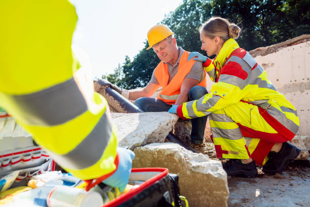 Emergency doctors giving first aid to construction worker Emergency doctors giving first aid to construction worker talking to the man car transporter stock pictures, royalty-free photos & images