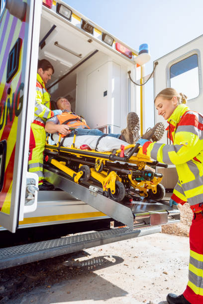 les ambulanciers paramédicaux mettent l’homme blessé sur la civière dans la voiture d’ambulance - ambulance healthcare and medicine germany car photos et images de collection