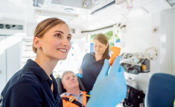 Paramedic looking after the drop injection in an ambulance Focused paramedic looking after the drop injection in an ambulance car car transporter stock pictures, royalty-free photos & images