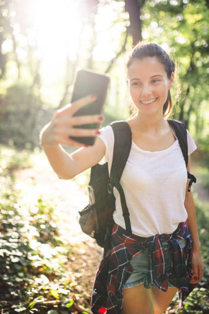 istock Woman taking a selfie and walking on mountain 1218842318