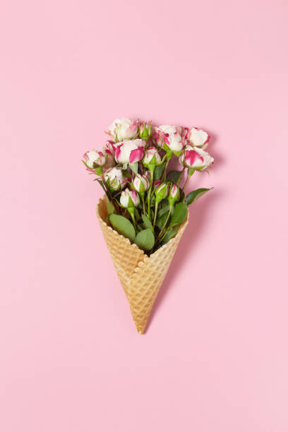 istock Small roses in waffle cone on pink background, copy space. Minimal style flat lay. For greeting card, invitation. March 8, February 14, birthday, Valentine's, Mother's, Women's day concept. Top view 1218842362