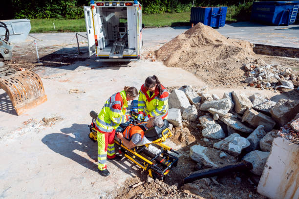 médico de urgencias y paramédico que cuida al hombre en el lugar del accidente - accident occupation physical injury construction fotografías e imágenes de stock