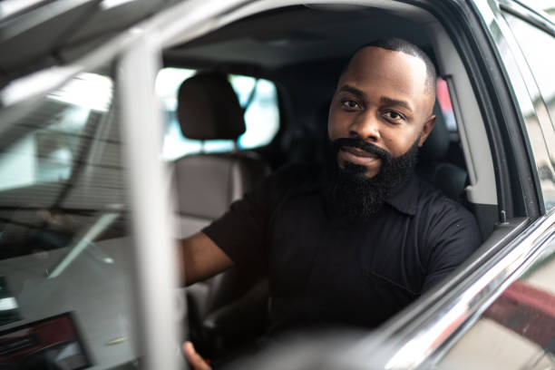 Portrait of African man inside a car Car mechanics, workers, customers, satisfaction / Auto car repair service center. car interior photos stock pictures, royalty-free photos & images