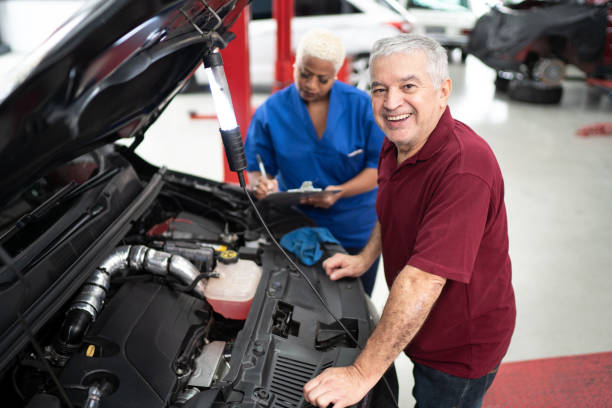 portrait of customer satisfied with the work done on his car with mechanics beside - old men car oil imagens e fotografias de stock