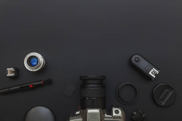 istock Photographer workplace with dslr camera system, camera cleaning kit, lens and camera accessory on dark black table background. Hobby travel photography concept. Flat lay top view copy space 1218845160