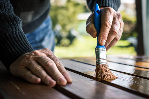 uomo anziano che dipinge tavolo di legno. ristrutturazione di mobili da giardino - brushing paint house painter human hand foto e immagini stock