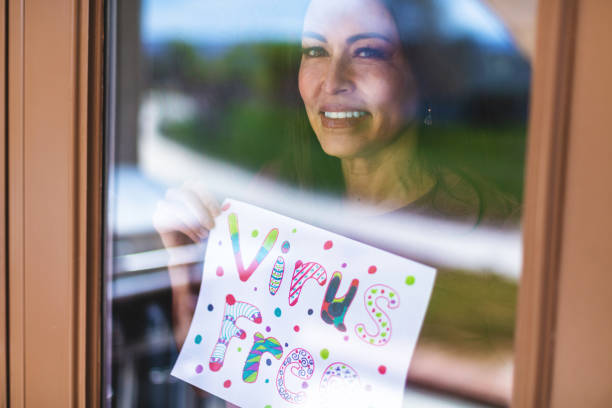 hermosa pre senior madura adulto femenino sosteniendo registro en ventana - women sign love trap fotografías e imágenes de stock