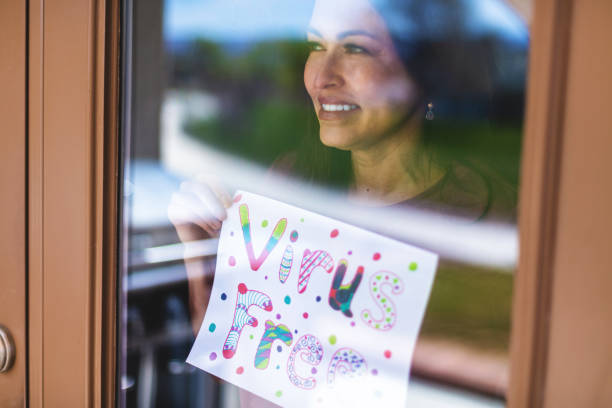 hermosa pre senior madura adulto femenino sosteniendo registro en ventana - women sign love trap fotografías e imágenes de stock