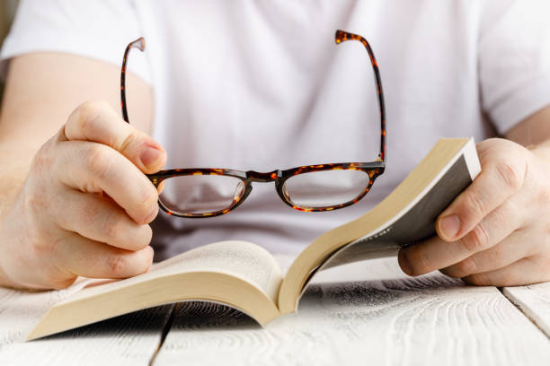 istock Reading book close up view in hands with glasses 1218851326