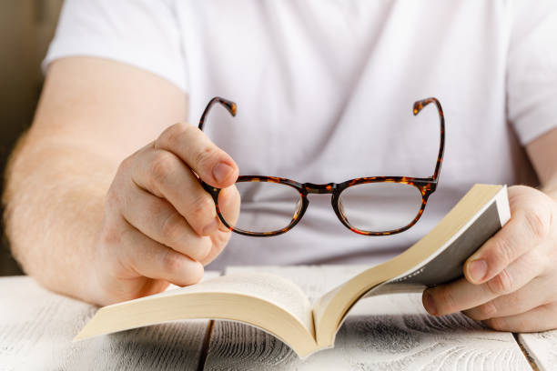istock Reading book close up view in hands with glasses 1218851478