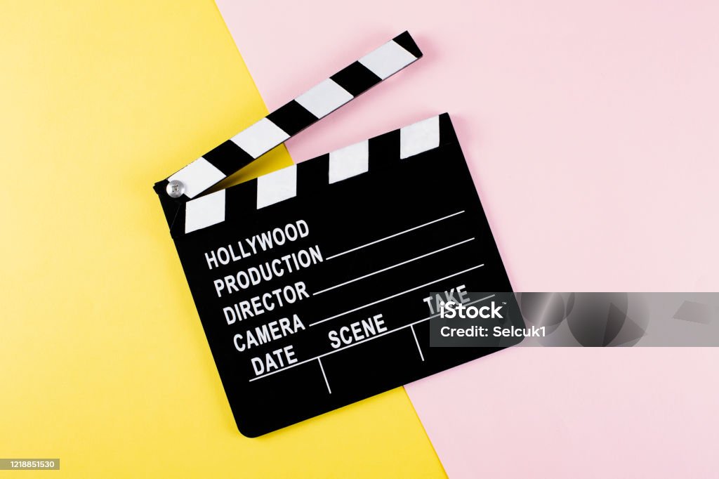 Movie clapper board on yellow and pink background with copy space. Oscar Statuette Stock Photo