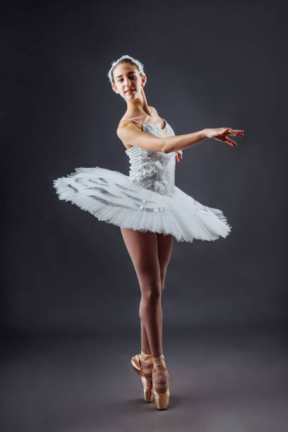 istock Graceful ballet dancer or classic ballerina dancing isolated on grey studio background. The dance, grace, artist, contemporary, movement, action and motion concept. Swan Lake Costume 1218852288