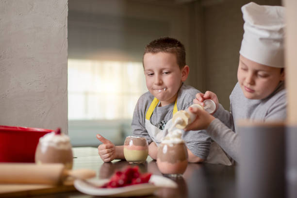 istock Two boys, brothers, preparing dessert at home 1218855801