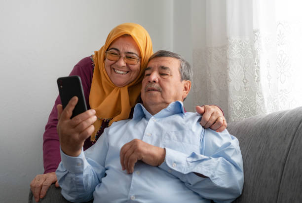 istock Senior couple using smartphone, having video call at home 1218856767