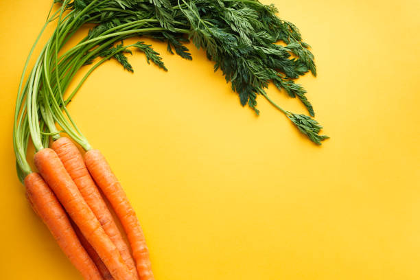 istock Flat lay composition with ripe fresh carrots on yellow background, with space for text 1218857002