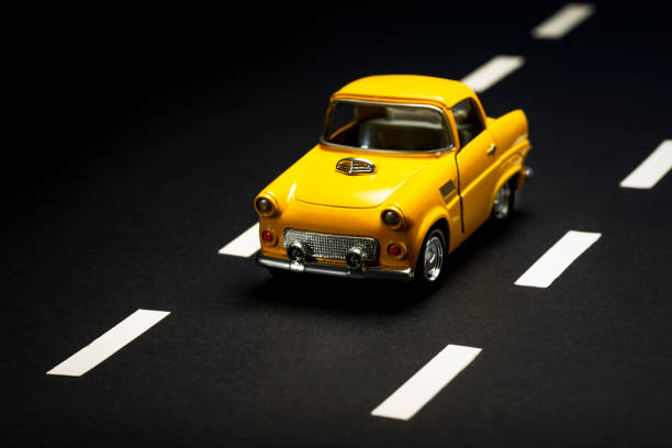 istock Yellow toy car on an asphalt road. 1218857659