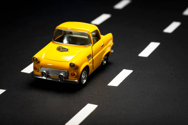 istock Yellow toy car on an asphalt road. 1218857665