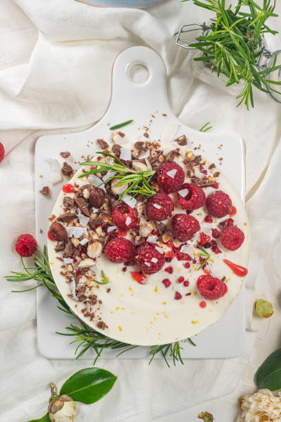 istock Cheesecake with raspberries, chocolate, hazelnuts and rosemary leaves on kitchen coutertop 1218860046