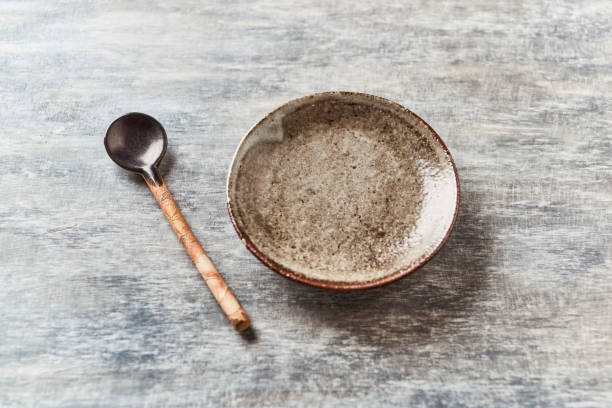 istock Empty ceramics plate and spoon on rustic wooden background.  Copy space. 1218860729