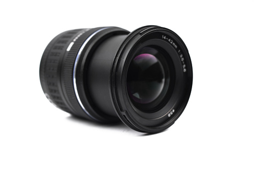 Front view of a single camera lens of black color placed on an isolated empty white background