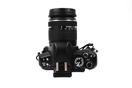 Side view of a black colored camera with lens attached to it on an isolated white background