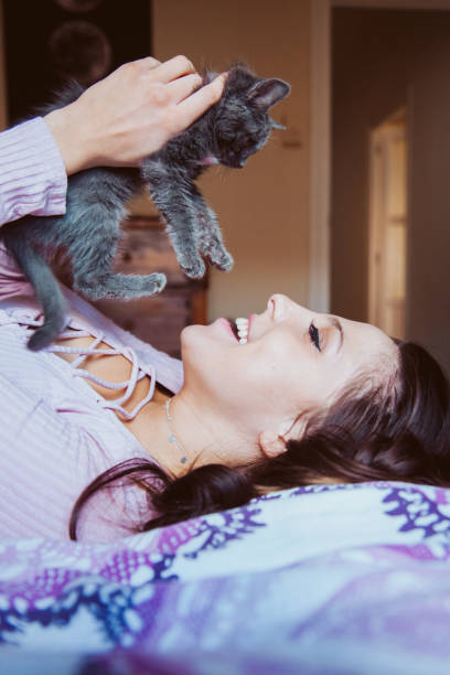 istock Young happy woman playing with a kitten with tender love. 1218862471