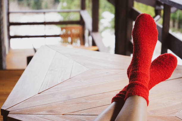 Legs of a young woman in socks on a wooden table, with space far text. Outside. stock photo